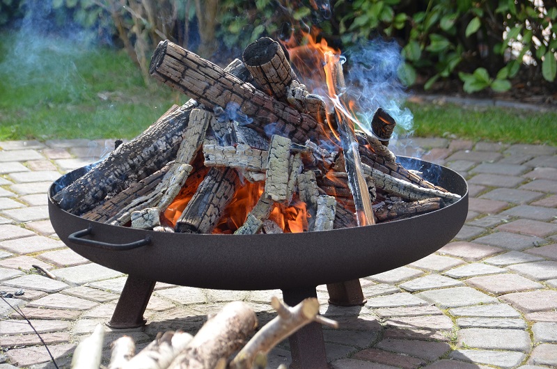 Brennende Feuerschale mit angebranntem Holz