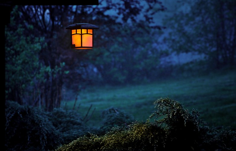 Gartenlampe hängt draußen in der Abenddämmerung